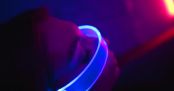 Cyberpunk style. Neon blue glasses glow on in a neon room. Close-up. Video Clip