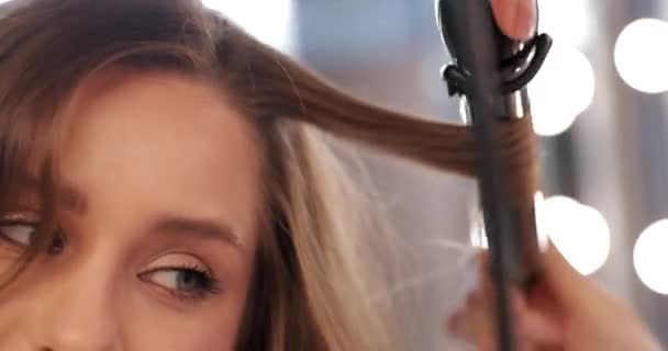 Young woman doing hairstyle in beauty salon. Close-up. — Stock Video