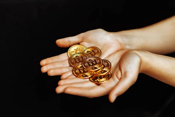 Bitcoins en la mano sobre un fondo negro. — Foto de Stock