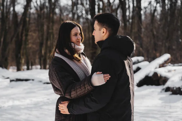 Kışın karlı bir arazide iki insan sıcacık bir kucaklaşmayla meşgul olur..