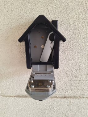 Açık bir duvara monte edilmiş anahtar kasasının yakın plan görüntüsü, anahtarları ortaya çıkarıyor ve içerideki mekanizmayı sıfırlıyor.