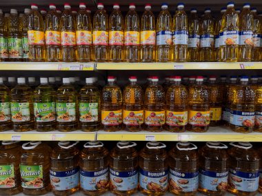 Perak, Malaysia - December 17, 2025 : Rows of palm and vegetable oil brands on display in a grocery store. Consumer goods, food retail, and household supplies on retail shelving.