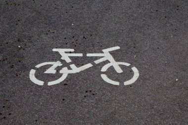 Gri asfalt yüzeyinde doğal kahverengi tohumlarla dağılmış bir bisiklet sembolünün üst görüntüsü. şehir ulaşımı ve bisiklet yolu kavramı.