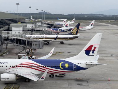 Kuala Lumpur, Malezya - 3 Haziran 2023: Malezya havaalanı terminali ve kapılarına park etmiş Singapur havayolları, uluslararası seyahat ve havacılık sektörünü gösteren yoğun bir havaalanı.