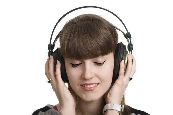 Mulher bonita em fones de ouvido grandes ouvindo música isolada. Olhos fechados. Sonho — Fotografia de Stock