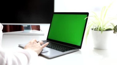 Kadın elleri dizüstü bilgisayarda klavye kullanıyor. yeşil ekran