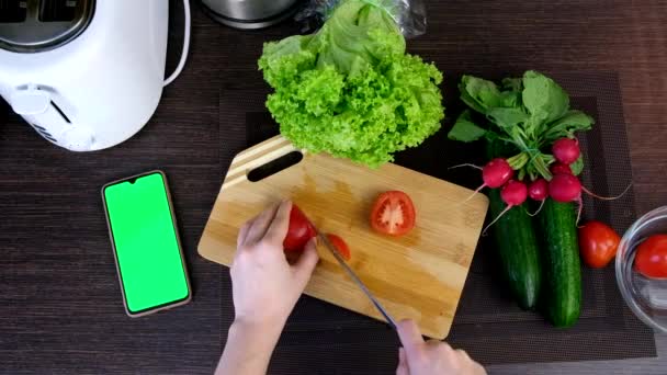 Személy nézet vágott paradicsom főzés friss növényi saláta telefon zöld képernyőn keresi recept — Stock videók