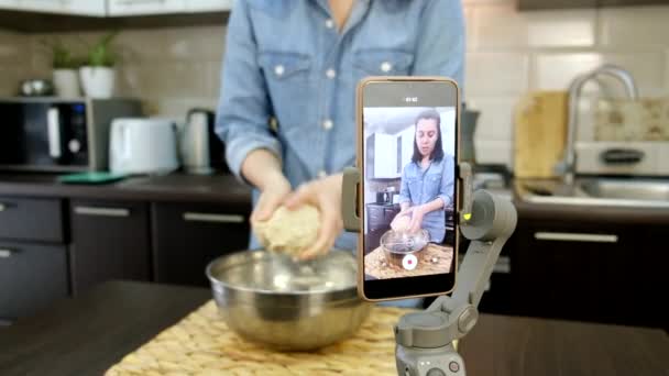 Kadın mutfakta yemek pişiriyor telefon yemek blogcusu vlogger 'da çekim yapıyor. — Stok video
