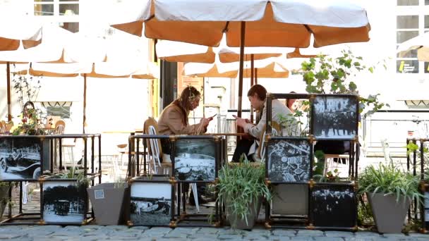 Lviv, Ucraina - 28 aprile 2021: amiche donne sedute all'aperto dipendenza dal telefono caffè — Video Stock