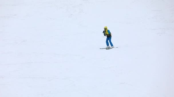 Esquiadora bajando por pendiente y disparando por teléfono — Vídeos de Stock