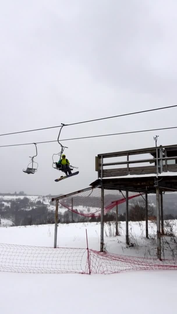 Snowboarder bij stoeltjeslift winteractiviteiten — Stockvideo