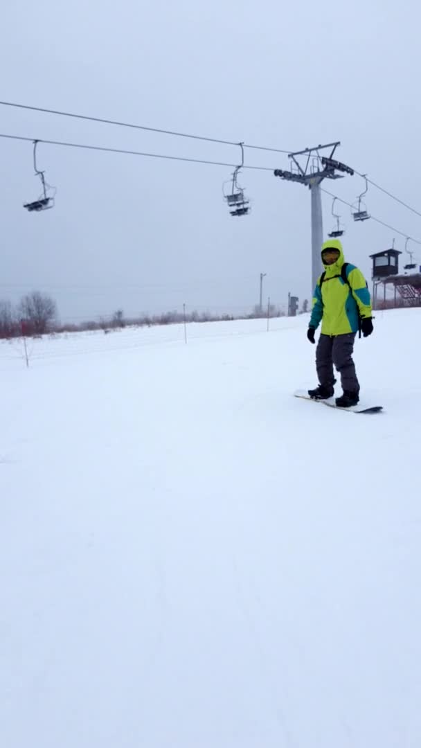 Hombre snowboarder cabalgando por la pista de esquí — Vídeos de Stock