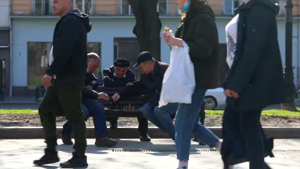 Lviv, Ukraine - 28. April 2021: Senioren sitzen auf der Bank und spielen Schach im öffentlichen Park — Stockvideo