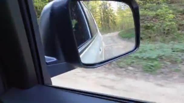 Reflectie in de auto spiegel rijden door bos trail — Stockvideo