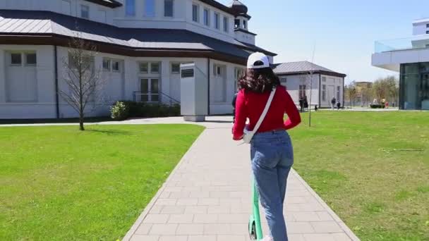 Nő lovagolni elektromos rúgás robogó napsütéses nap — Stock videók