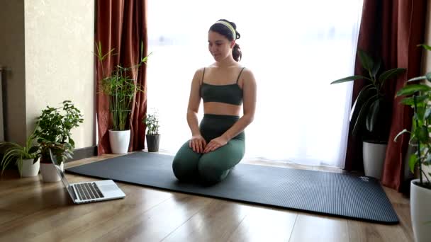 Jeune jolie femme faire du yoga à la maison près de la grande fenêtre — Video