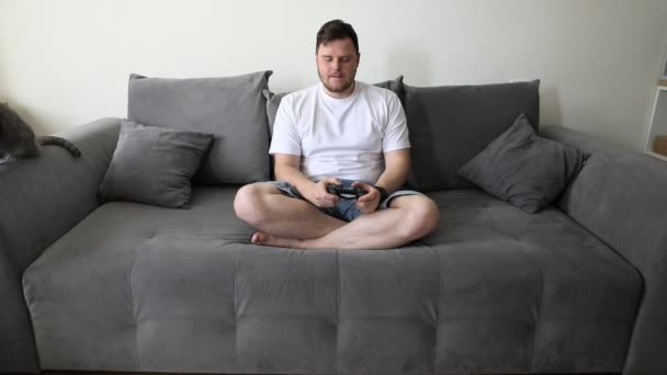 Homme jouant à des jeux vidéo sur console émotions différentes bonheur en colère — Video