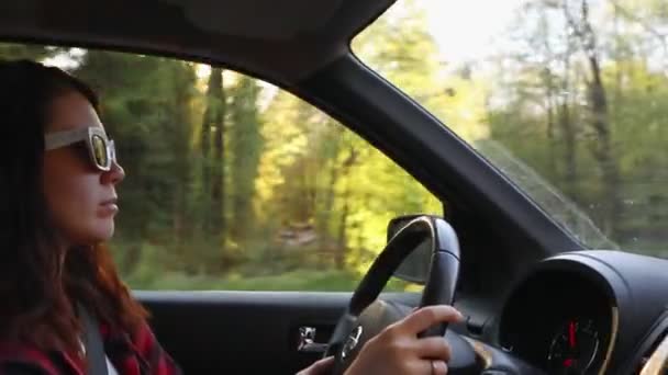 Mujer conduciendo coche en el espacio de copia puesta del sol — Vídeo de stock