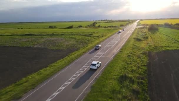 Εναέρια παρακολούθηση άποψη μετά SUV αυτοκίνητο κινείται με αυτοκινητόδρομος στο ηλιοβασίλεμα — Αρχείο Βίντεο