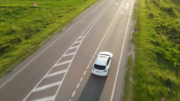 Seguimiento de la vista aérea después de que el coche suv se mueva por la senda rápida en la puesta del sol — Vídeo de stock