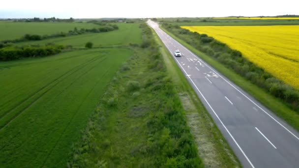 Seguimiento de la vista aérea después de que el coche suv se mueva por la senda rápida en la puesta del sol — Vídeo de stock