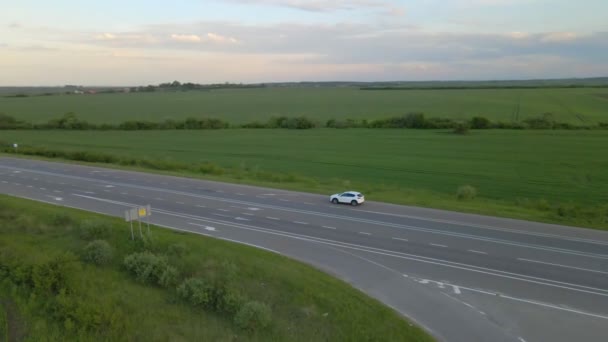 Letecký pohled sledování po SUV auto pohybující se po dráze při západu slunce — Stock video