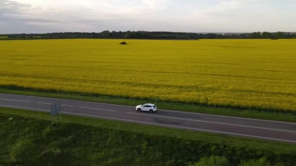 Seguimiento de la vista aérea después de que el coche suv se mueva por la senda rápida en la puesta del sol — Vídeos de Stock