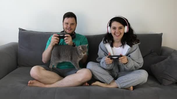 Paar samen spelen video games zitten op de bank — Stockvideo