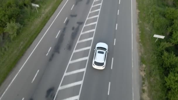 Widok z lotu ptaka śledzenie po SUV samochód poruszający się po autostradzie na zachód słońca — Wideo stockowe