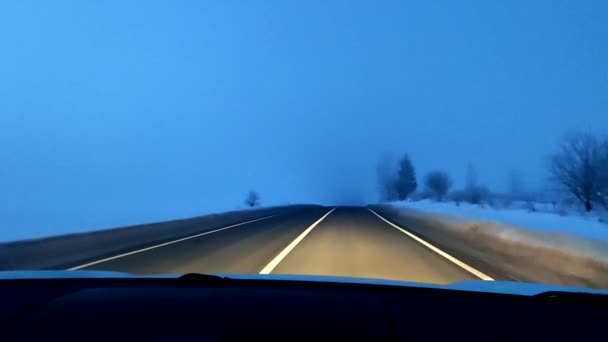 Güneşin doğuşunda sisli bir yolda kötü bir görüşle araba sürmek — Stok video