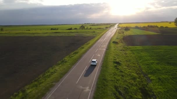 Suivi de vue aérienne après que la voiture suv se déplace par speedway sur le coucher du soleil — Video