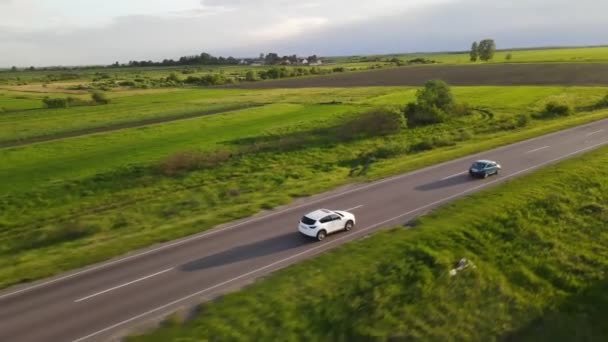 Suivi de vue aérienne après que la voiture suv se déplace par speedway sur le coucher du soleil — Video