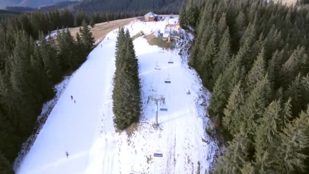 Vista superior aérea da encosta de inverno nevado pessoas esqui e snowboard — Vídeo de Stock