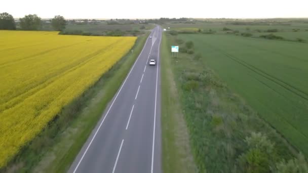 Seguimiento de la vista aérea después de que el coche suv se mueva por la senda rápida en la puesta del sol — Vídeo de stock