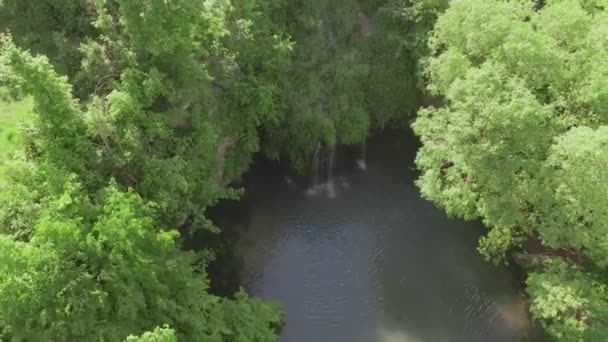 Вид зверху на невеликий водоспад з блакитним озером — стокове відео