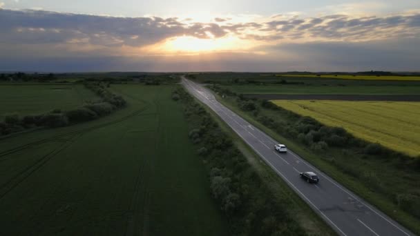 Suivi de vue aérienne après que la voiture suv se déplace par speedway sur le coucher du soleil — Video