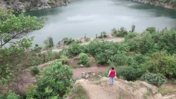 Mujer excursionista disfrutando de la vista de la vieja mina inundada — Vídeos de Stock