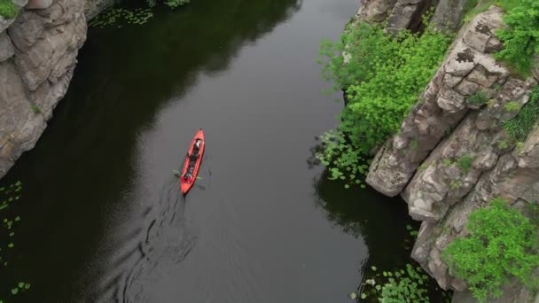 Luftaufnahme von Menschen, die mit dem Kajak durch einen Fluss in einer Schlucht fahren — Stockvideo