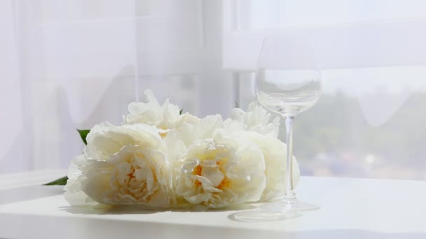 Pioner blommor på bordet hälla vin glas — Stockvideo