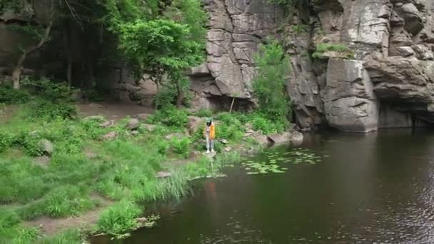 Woman hiker walking by beach enjoying view of canyon with river — Stock Video