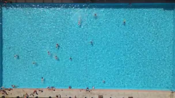 Vue aérienne de la piscine de la ville publique aux personnes ensoleillées de jour chaud nageant — Video