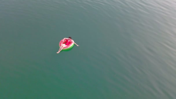 Overhead top view of woman swimming with watermelon swimming circle in blue water — Stock Video