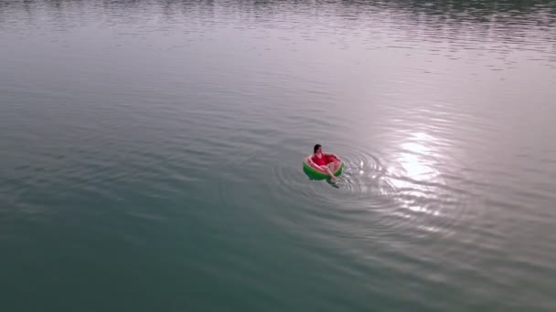 Overhead top view of woman swimming with watermelon swimming circle in blue water — Stock Video