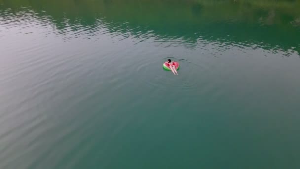 Shora pohled na ženu plavající s vodním melounem plavecký kruh v modré vodě — Stock video
