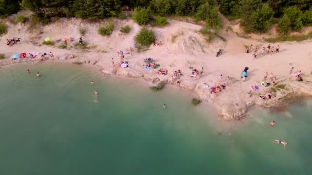 Вид с воздуха на песчаный пляж на озере с голубой водой — стоковое видео