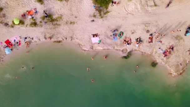 Widok z lotu ptaka piaszczystej plaży nad jeziorem z błękitną wodą — Wideo stockowe
