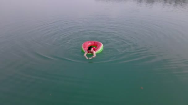 Vista dall'alto della donna che nuota con il cerchio di nuoto dell'anguria in acqua blu — Video Stock