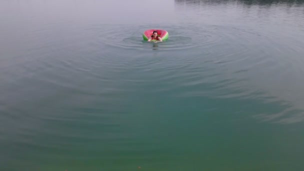 Vista superior de la mujer nadando con el círculo de natación sandía en agua azul — Vídeos de Stock