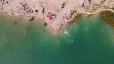 Göl kenarındaki kumsal manzaralı mavi su.