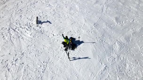 Skifahrerpaar und Snowboarder amüsieren sich bei sonnigem Wetter oben auf der Schanze — Stockvideo